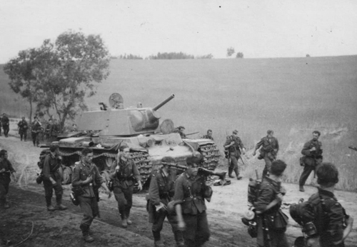 A KV-1 heavy tank is a curiosity to passing German soldiers